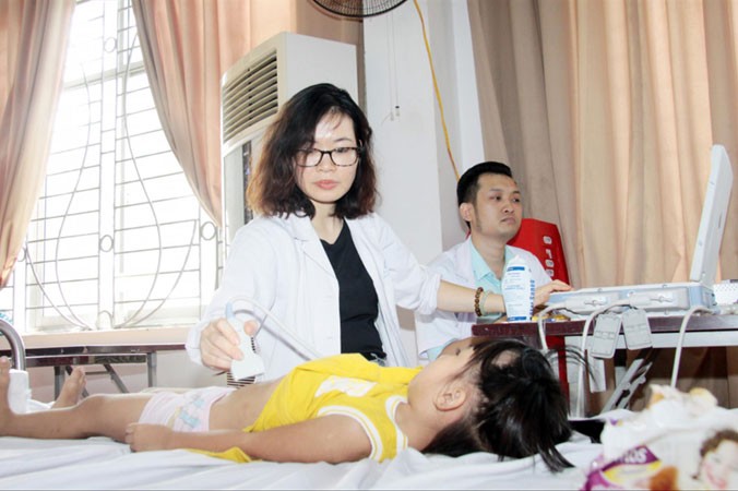 Các y, bác sĩ khám bệnh cho con công nhân ở Ðông Anh (Hà Nội). Ảnh: CTV.