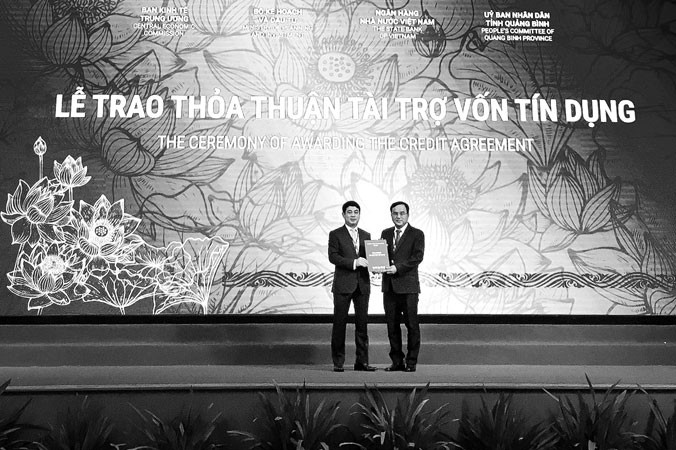 Ðại diện Vietcombank, ông Nghiêm Xuân Thành - Chủ tịch HÐQT (bên trái) trao bản thỏa thuận nguyên tắc thu xếp vốn đối với dự án Nhà máy nhiệt điện Quảng Trạch 1 cho đại diện Tập đoàn Ðiện lực Việt Nam, ông Dương Quang Thành - Chủ tịch Tập đoàn.