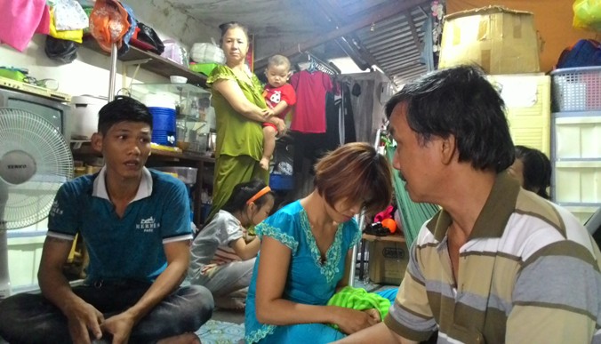 Trong căn nhà chưa đầy 15m2, 13 người vừa lớn vừa nhỏ tá túc (ông Minh ở bìa phải). Ảnh: Việt Văn
