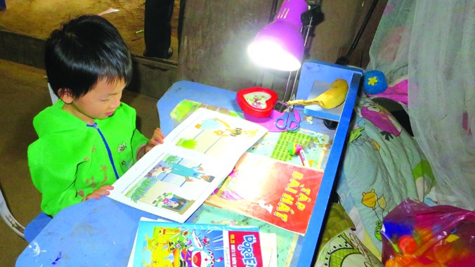 Trẻ em Nà Ròn được học tập dưới ánh đèn. Ảnh: Quỳnh Nga