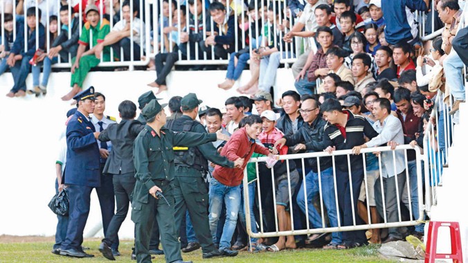  Lực lượng bảo vệ mở hàng rào cho khán giả tràn xuống đường piste sau khi lượng CĐV vào sân vượt sức chứa của sân Pleiku. Ảnh: VSI