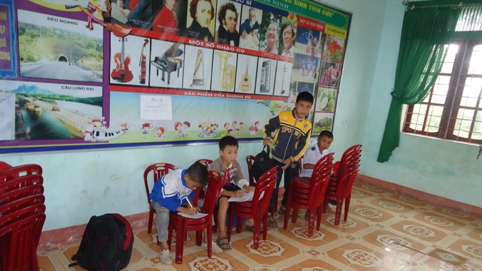  Không chỉ dùng bục giảng làm bàn, các em học sinh ở trường Tiểu học số 1 An Ninh còn phải chồng ghế làm bàn để ghi bài