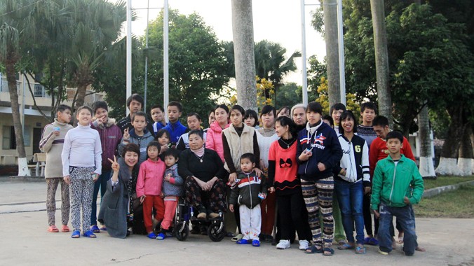 Các em nhỏ và người già được chuyển từ chùa Bồ Đề lên chụp ảnh cùng các thành viên khác ở Trung tâm nuôi dưỡng người già và trẻ tàn tật Hà Nội. Ảnh: Tuấn Nguyễn