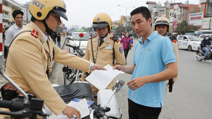 Tổ cơ động mạnh, CSGT Công an thành phố Hà Nội lập biên bản phạt lái xe taxi dừng đỗ sai. Ảnh: Hồng Vĩnh