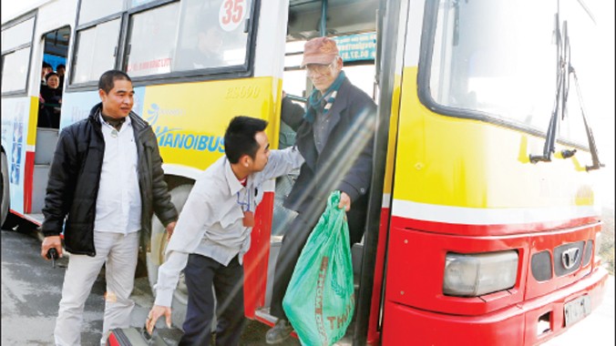 Nhân viên xe buýt Hà Nội giúp đỡ khách xuống xe tại tuyến Mê Linh. Ảnh: Hồng Vĩnh
