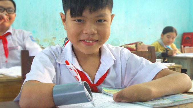 Phan Trọng Hiếu - cậu học trò nhỏ gan góc kiên trì với cây bút đặc biệt. Ảnh: Nguyễn Trang