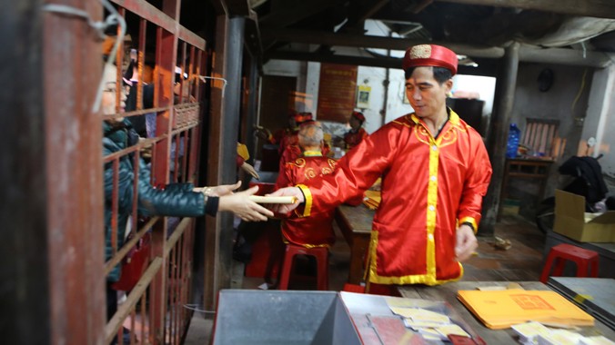 Cảnh “bỏ tiền, phát ấn” tại Lễ hội đền Trần (Nam Định). Ảnh: Như Ý