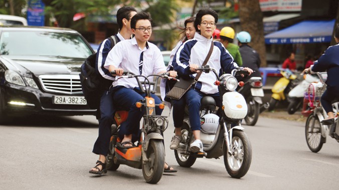Học sinh trường THPT Việt Đức đi xe đạp điện không đội mũ khi tham gia giao thông trên đường, ảnh chụp trưa ngày 8/4. Ảnh: Ngọc Châu