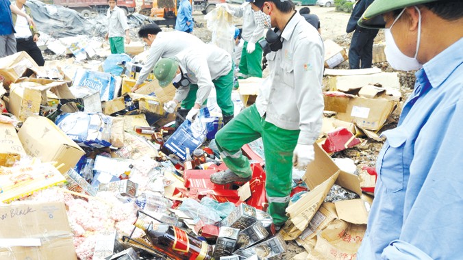 Tiêu hủy rượu giả, thuốc lá và mỹ phẩm nhái tại khu xử lý rác thải của Cty Môi trường đô thị và Công nghiệp 11 (Hưng Yên). Ảnh: Anh Tuấn