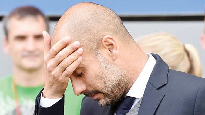 Pep Guardiola ôm đầu buồn bã sau thất bại của Bayern Munich trước Freiburg. Ảnh: EPA