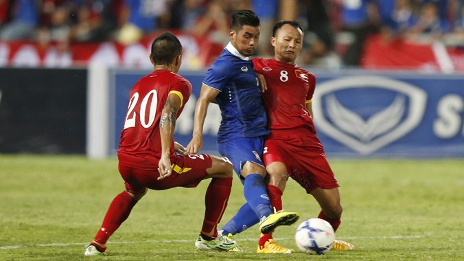 Cầu thủ Thái Lan (giữa) vất vả vượt qua lối chơi quyết liệt, lăn xả của các cầu thủ Việt Nam ở trận đầu ra quân vòng loại World Cup 2018. Ảnh: VSI