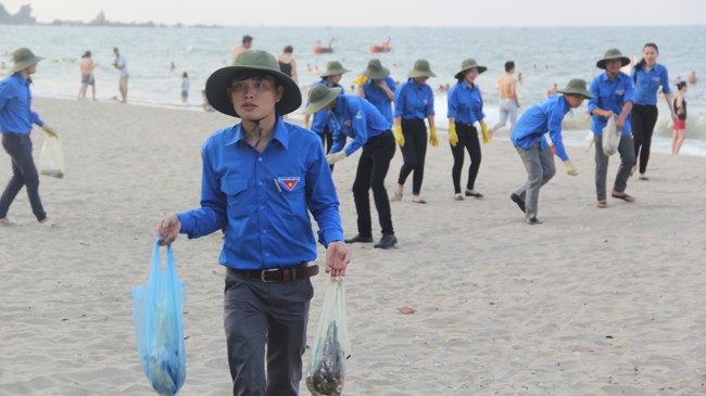 Thanh niên tình nguyện nhặt rác tại bãi biển Cửa Lò (Nghệ An). Ảnh: Phan Sáng