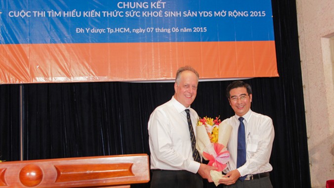 TS. Ngô Đồng Khanh (phải), Phó Hiệu trưởng trường ĐH Y Dược TPHCM trao hoa lưu niệm cho đại diện đơn vị tài trợ - Ông David J. Champion, Tổng Giám đốc Bayer Việt Nam