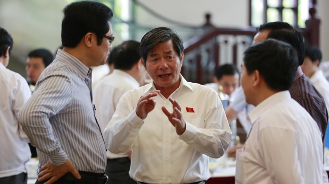 Bộ trưởng Bùi Quang Vinh trao đổi với các đại biểu bên lề Quốc hội. Ảnh: Hồng Vĩnh