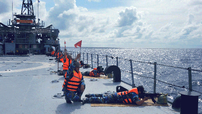Bộ đội đeo mặt nạ phòng hóa thực hành bắn súng tiểu liên AK trên tàu 501