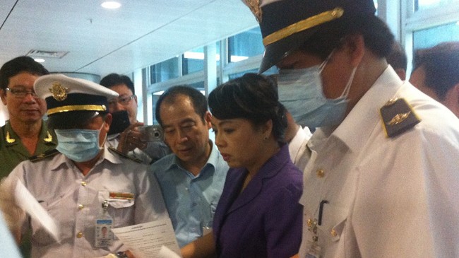Bộ trưởng Nguyễn Thị Kim Tiến theo dõi hoạt động kiểm tra tờ khai y tế đối với hành khách Hàn Quốc vừa đáp xuống sân bay Tân Sơn Nhất trưa 19/6. Ảnh: Quốc Ngọc