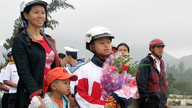  Chị Trần Thị Hiền cùng hai con trai mang hoa đi đón chồng chị, Trung tá Phạm Văn Lợi trở về bến cảng Cam Ranh ngày 26/1/2011, sau 18 tháng làm nhiệm vụ tại đảo Song Tử Tây