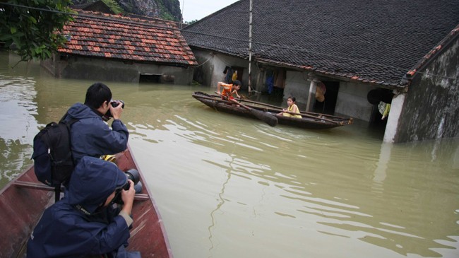 Phóng viên tác nghiệp trong vụ ngập lụt tại Thạch Thất, Hà Tây, Hà Nội. Ảnh: Như Ý