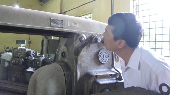Trưởng khoa Cơ điện, Học viện Nông nghiệp Việt Nam Lê Minh Lư (SN 1961) bên một cỗ máy có tuổi đời ngang bằng với số tuổi của ông. Ảnh: HB