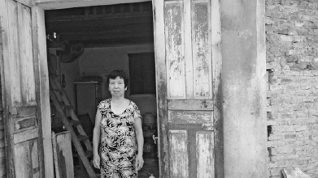 Cựu TNXP Hoàng Thị Minh trước căn nhà đã ở nhiều năm nay
