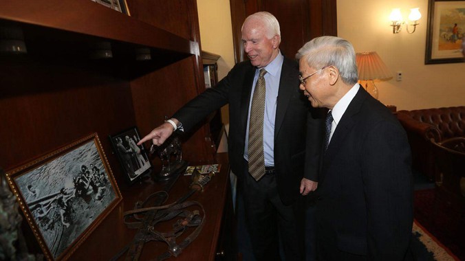 Thượng nghị sĩ Mỹ John McCain giới thiệu với Tổng Bí thư Nguyễn Phú Trọng một số ảnh tư liệu. Ảnh: TTXVN