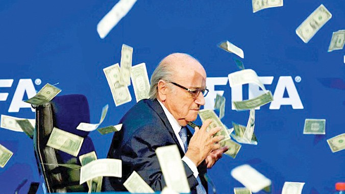 Chủ tịch FIFA Sepp Blatter lúng túng hứng cơn mưa tiền trong buổi họp báo. Ảnh: AP