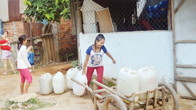 Chị Thanh và bé Trinh phải đi mua từng can nước sạch về sử dụng