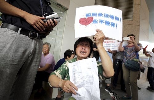 Một thân nhân hành khách đến trước văn phòng của Malaysia Airlines tại Bắc Kinh, Trung Quốc, yêu cầu hãng này có câu trả lời xác đáng về số phận chiếc MH370 - Ảnh: Reuters