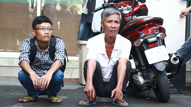 Ông Nguyễn Văn Hai và đứa cháu trai ngồi đợi nhận hồ sơ tại ĐH Công nghiệp TPHCM