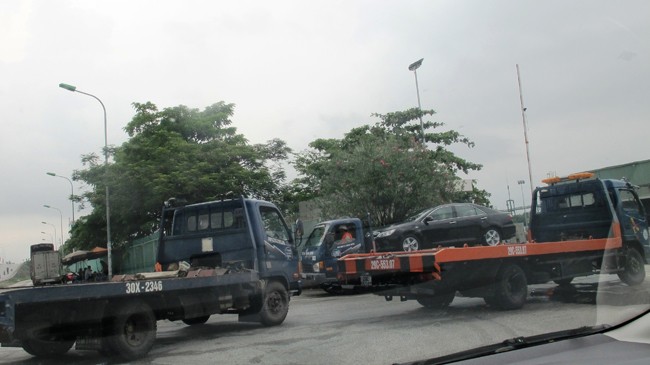 Xe cứu hộ nối đuôi nhau ra vào nhà máy của Toyota Việt Nam nhận xe. Ảnh: SỸ LỰC