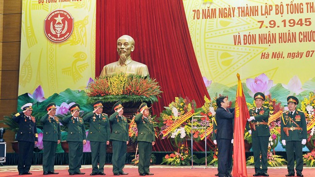 Chủ tịch nước Trương Tấn Sang gắn Huân chương Quân công hạng Nhất lên lá cờ truyền thống của Bộ Tổng tham mưu. Ảnh: Trọng Đức
