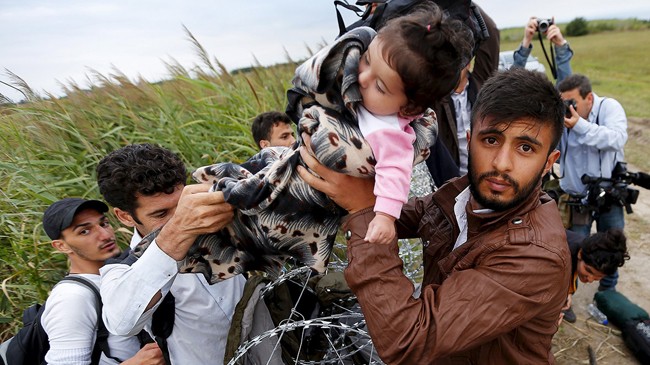 Một nhóm người di cư từ Syria vượt qua biên giới Hungary. Ảnh: IBTimes