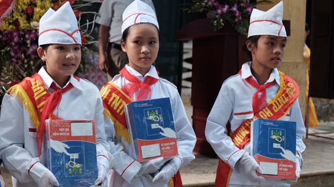 Học sinh Trường Tiểu học Đồng Lạc vui mừng nhận vở từ những người thợ điện Thủ đô