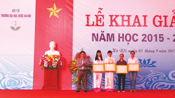 Ông Nguyễn Văn Đình - phó giám đốc công ty TNHH Dược phẩm Hoa Linh trao học bổng cho 4 nữ sinh viên của Đại học Dược có thành tích học tập xuất sắc