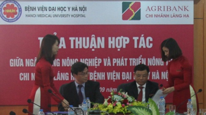 Ông Hồ Văn Sơn - GĐ Agribank Láng Hạ (phải) và ông Phạm Đức Huấn - GĐ Bệnh viện Đại học Y Hà Nội đại diện hai đơn vị ký kết thỏa thuận hợp tác