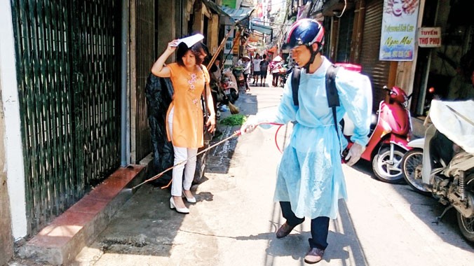 Nhân viên đang phun thuốc phòng chống dịch sốt xuất huyết tại ngõ Yên Thái, quận Hoàn Kiếm, Hà Nội. Ảnh: Ngọc Châu