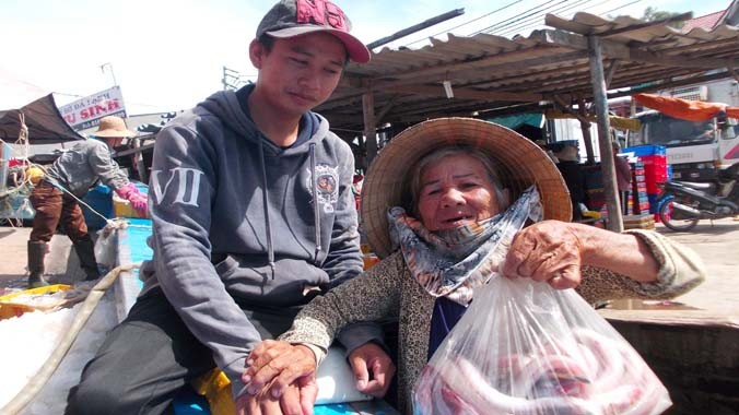Bà Trần Thị Chướng may mắn được ngư dân cho hàng chục ký cá từ chiếc thuyền vừa trở về.