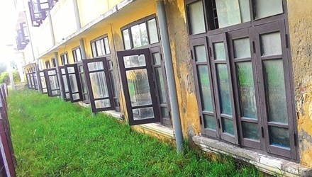 Phần tường bên dưới các ô cửa sổ tầng trệt của Trường THPT Thuận An đã lún gần bằng với mặt sân sau tòa nhà. 