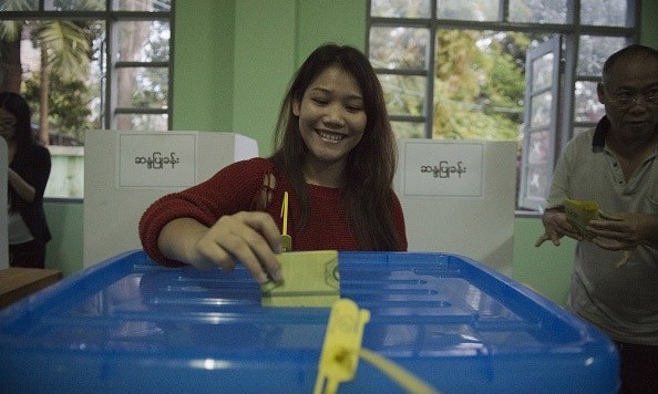 Một cô gái cười tươi khi bỏ lá phiếu tại điểm bầu cử.