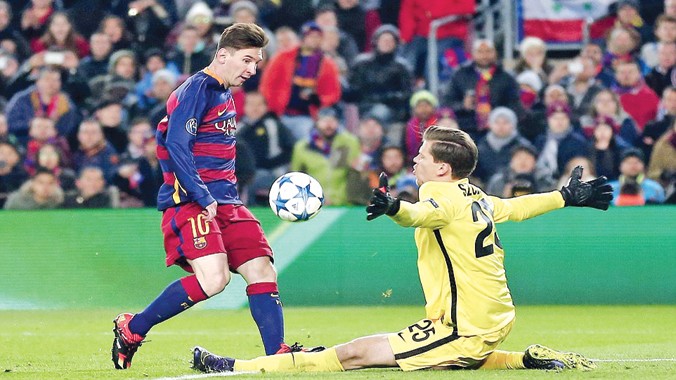 Messi tâng bóng qua đầu thủ môn Szczesny ghi bàn thắng cho Barca. Ảnh: AP