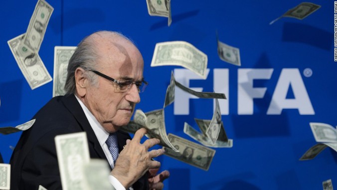 Ông Sepp Blatter bị rải một cơn mưa tiền giả trong cuộc họp báo hồi tháng 7. Ảnh: GETTY IMAGES