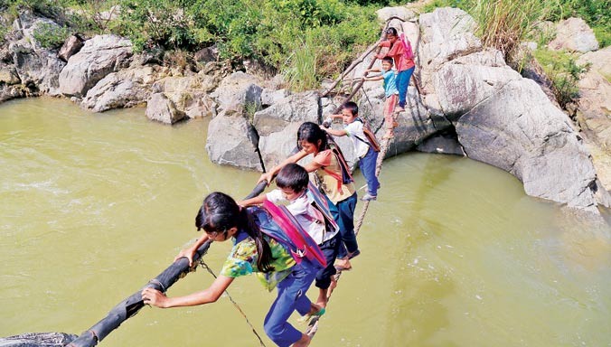 Các em học sinh bản Cu Pua và người dân qua sông bằng sợi dây cáp. ẢNH: H.T