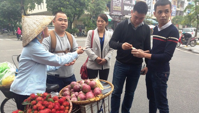 Nhóm du khách Trung Quốc mua trái cây từ hàng rong trên phố.