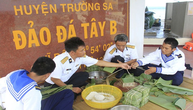 Cán bộ, chiến sĩ đảo Đá Tây B gói bánh chưng đón Tết. Ảnh: Trường Phong