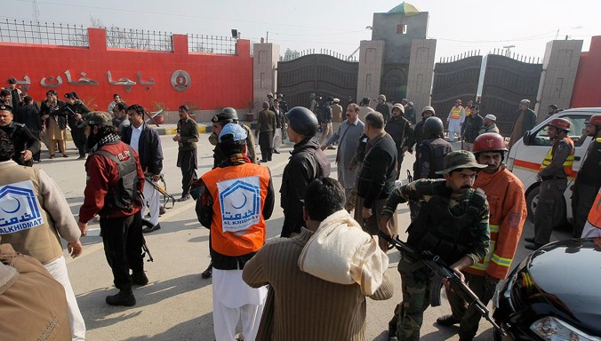 Binh sĩ và nhân viên cứu hộ tập trung trước cổng chính ĐH Bacha Khan. Ảnh: AP