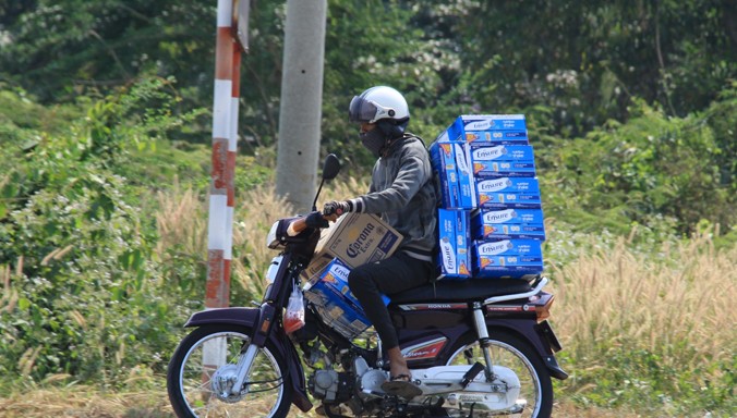 Vận chuyển sữa lậu dưới trời nắng bằng xe máy.