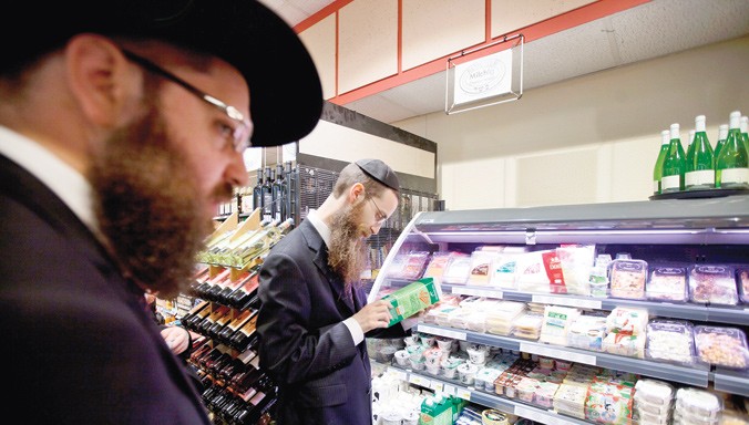 Hai người Do Thái chính thống lựa chọn đồ ăn Kosher tại một siêu thị ở Ðức. Ðồ ăn Kosher đắt hơn thức ăn thông thường 20-30%. Ảnh: Vosizneias