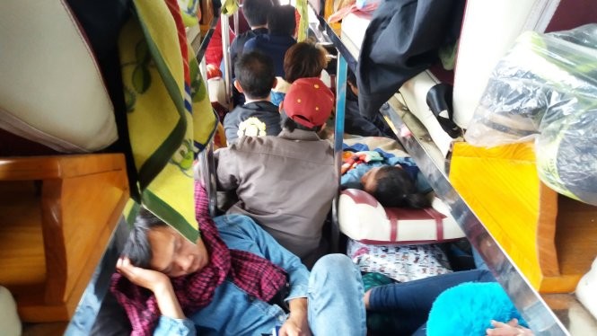 Hành khách nằm ngồi chen chúc trên chuyến xe từ Lào về quê 
