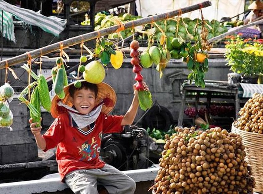 Chú bé với cây “bẹo” của thuyền bán trái cây.
