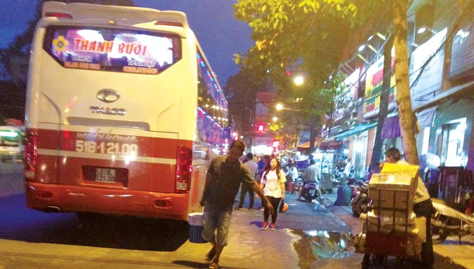 Xe hợp đồng chở khách theo tuyến cố định của Cty Thành Bưởi đỗ trên đường Lê Hồng Phong (TPHCM). Ảnh: Bảo An